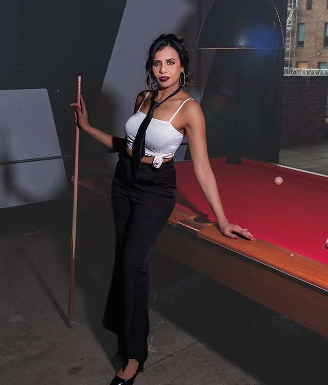 Natasha playing pool in a monochrome outfit